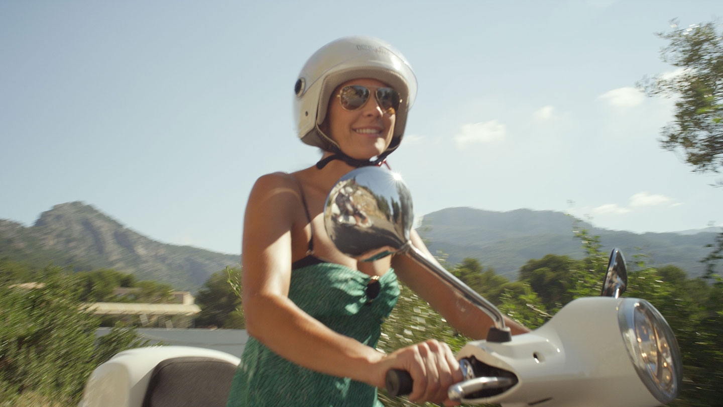 Women riding a vespa in Port Soller mountains