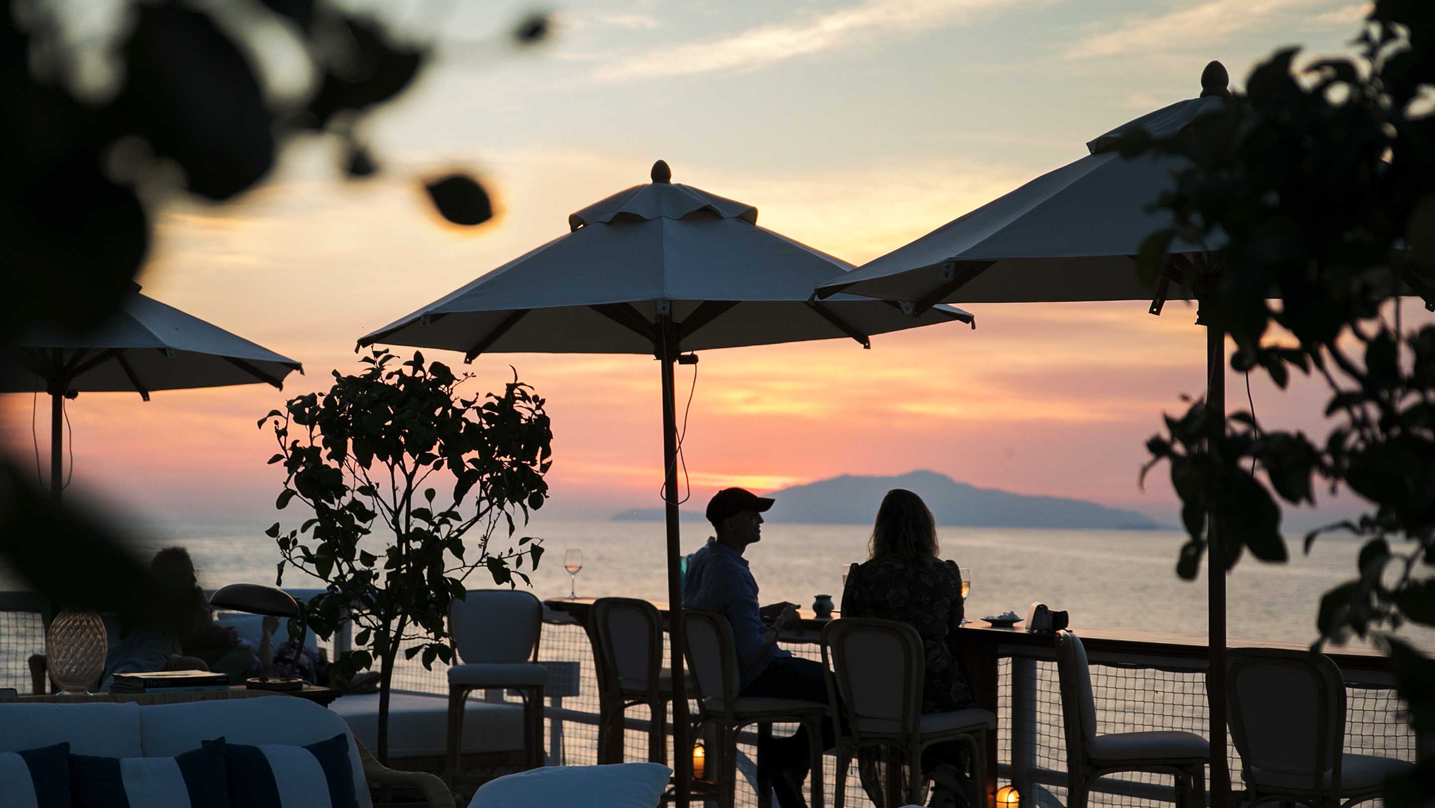 A couple enjoying drinks at sunset at Capri Palace Jumeirah