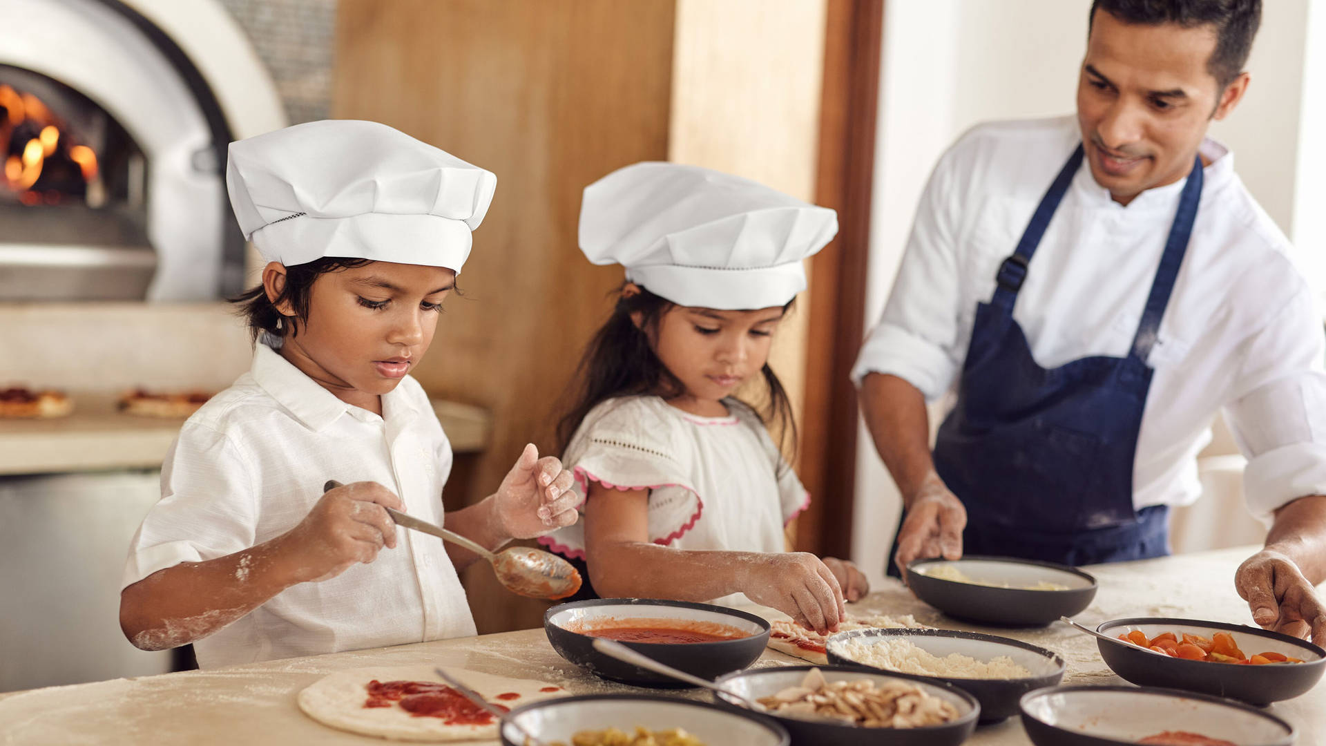 Kids making pizza at Jumeirah Maldives Olhahali Island