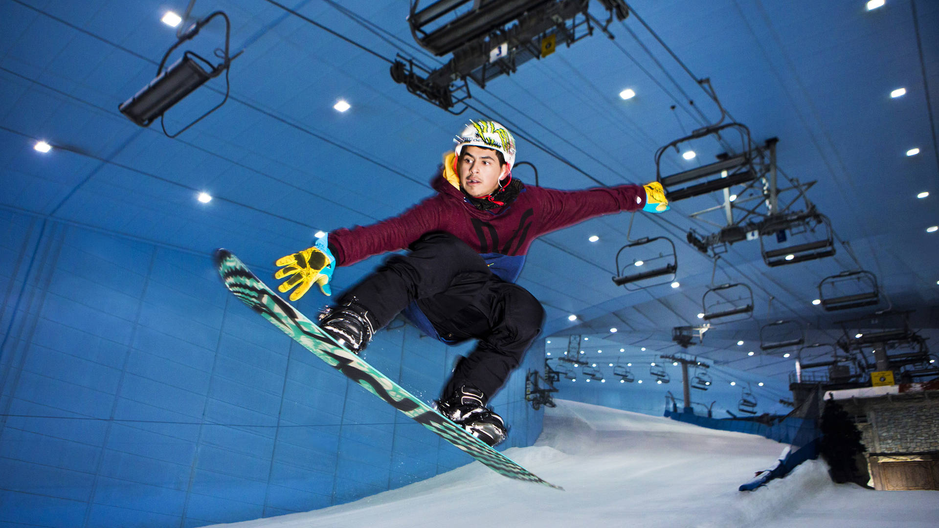 A young boy snowboard's down Ski Dubai's slope