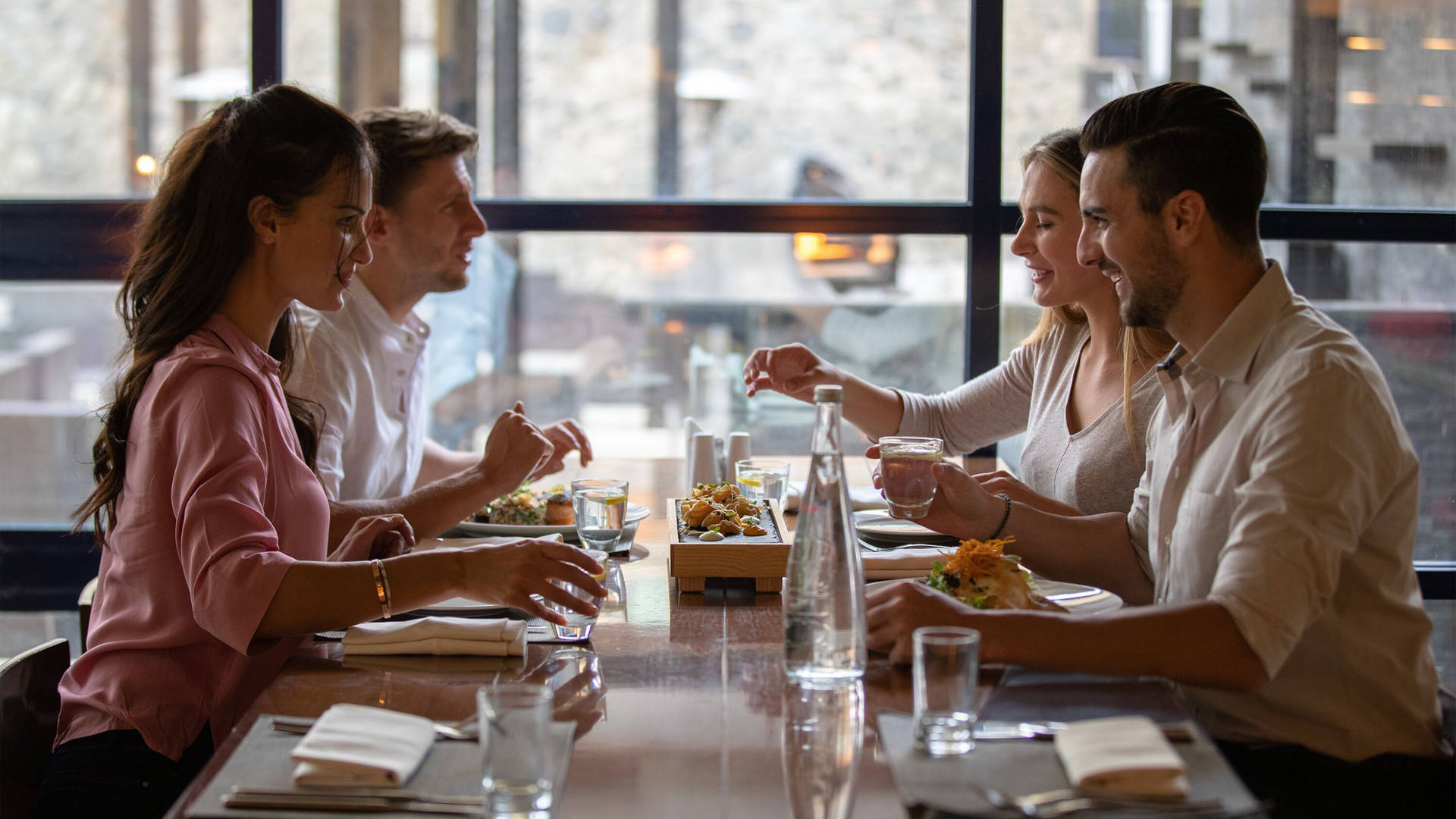 Image of four friends relaxing together over dinner at Jumeirah Creekside Hotel
