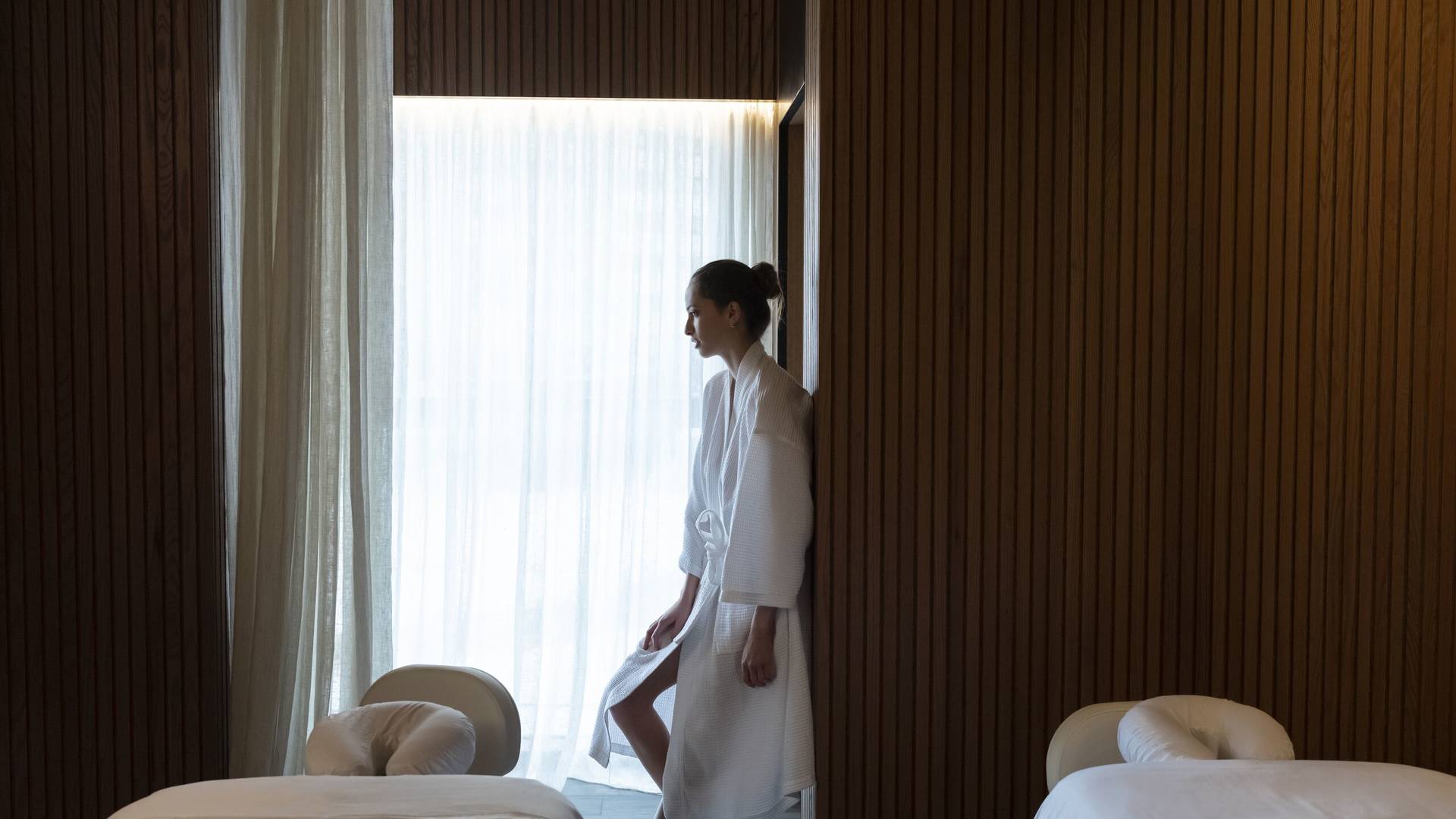 Lady standing by a curtain at Jumeirah Zabeel House Native Club Spa at The Greens