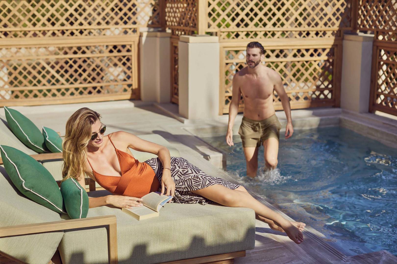 A couple relaxing in the private pool at Malakiya Villas