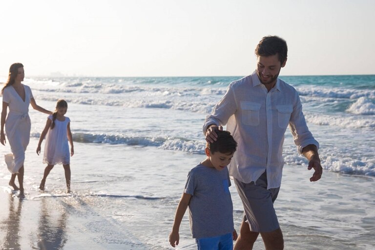 Image of a family walking along the sea shore