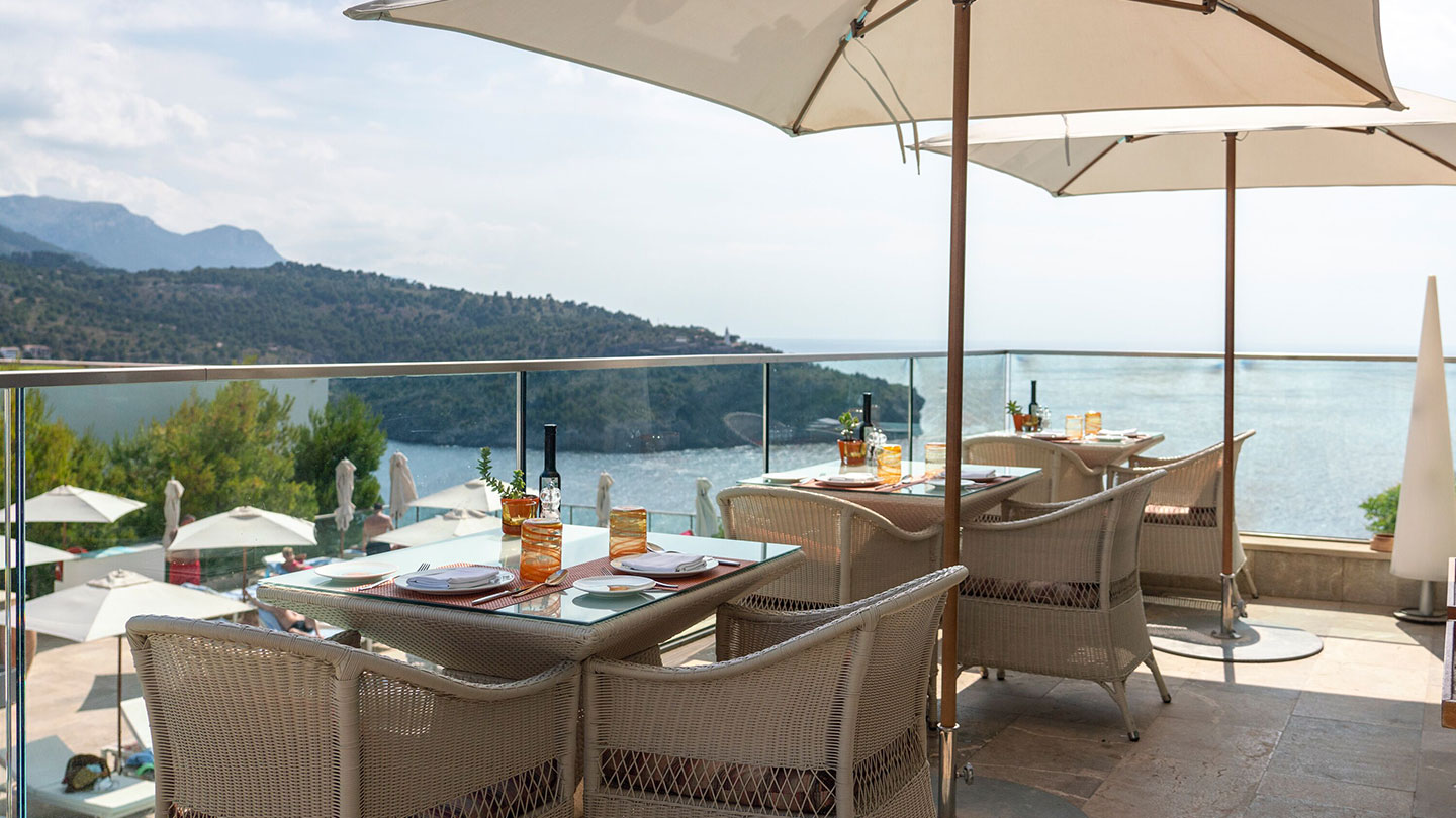 Mesas de restaurante en la terraza con vistas al Port de Sóller