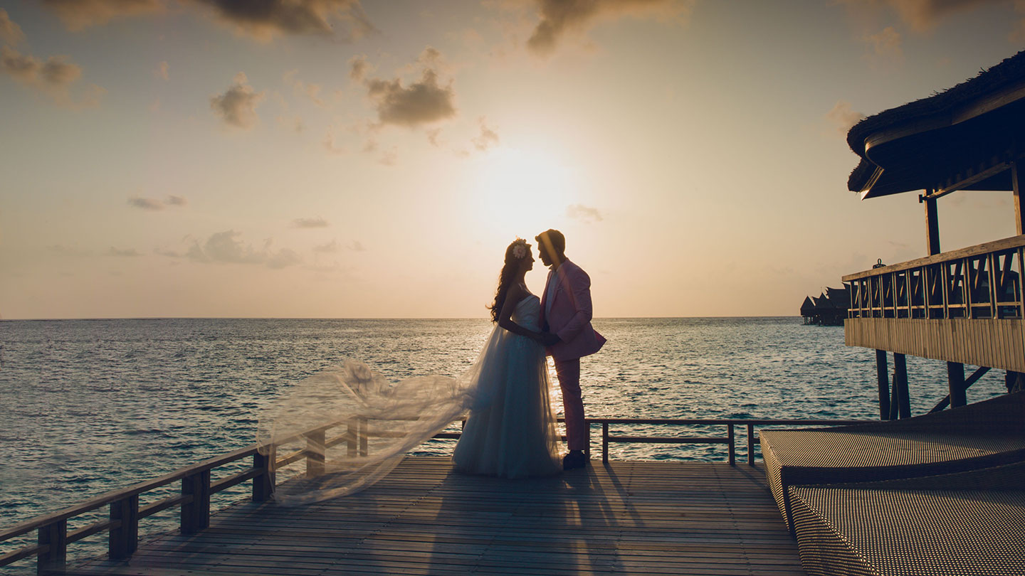 Курорт Jumeirah Vittaveli — силуэт пары у моря на свадебной церемонии