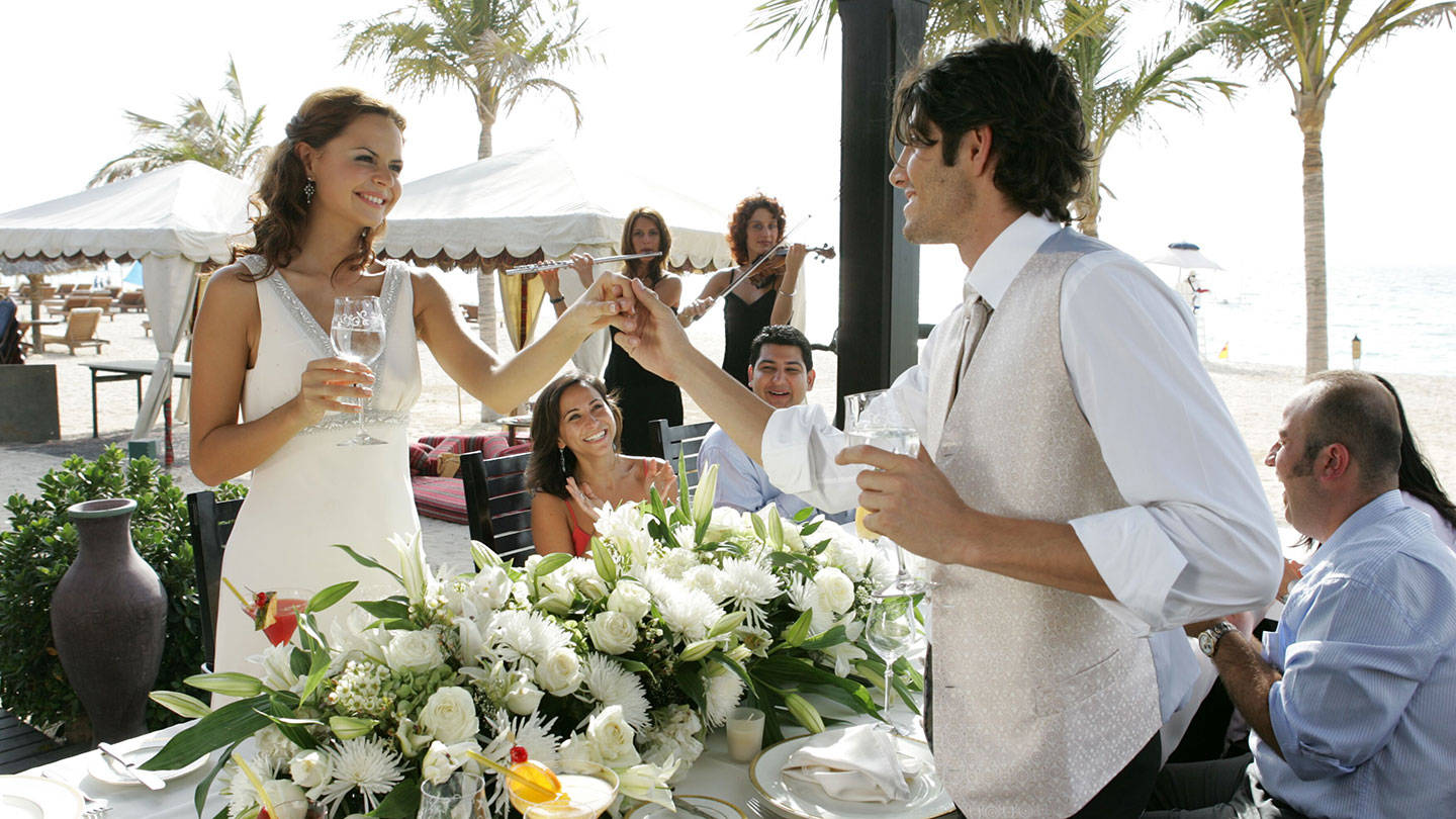 卓美亚古堡酒店海滨婚礼上举杯庆祝的新人