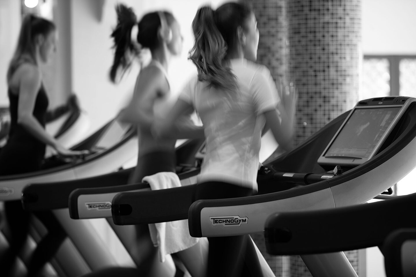 Women running on treadmills black and white