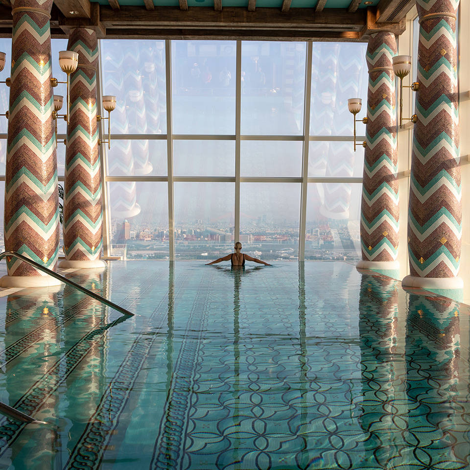 Женщина в бассейне спа-центра Talise Spa с видом на город в отеле Burj Al Arab Jumeirah 