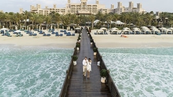 卓美亚皇宫酒店在码头海滩上的情侣 