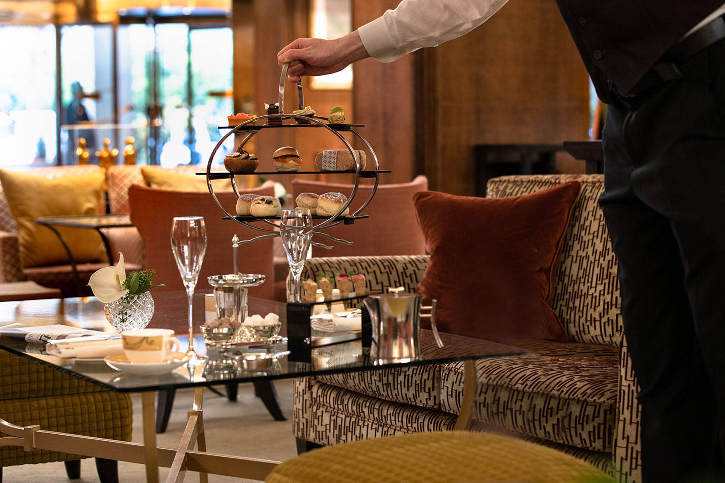 Официант ставит поднос с чаем в ресторане Chinoiserie в отеле Jumeriah Carlton Tower