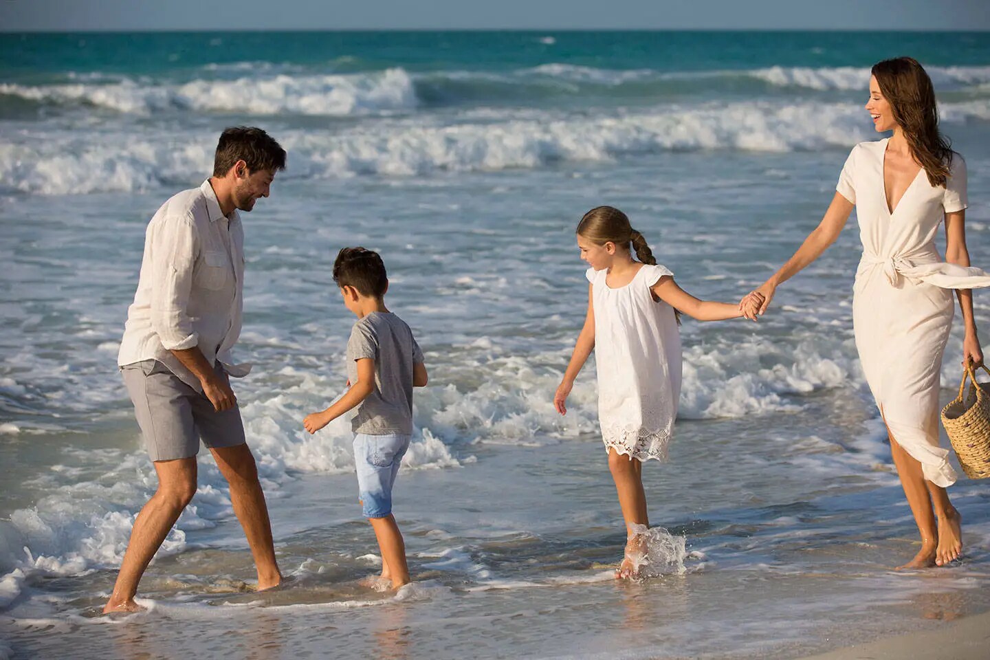 Family walking hand in hand on beach