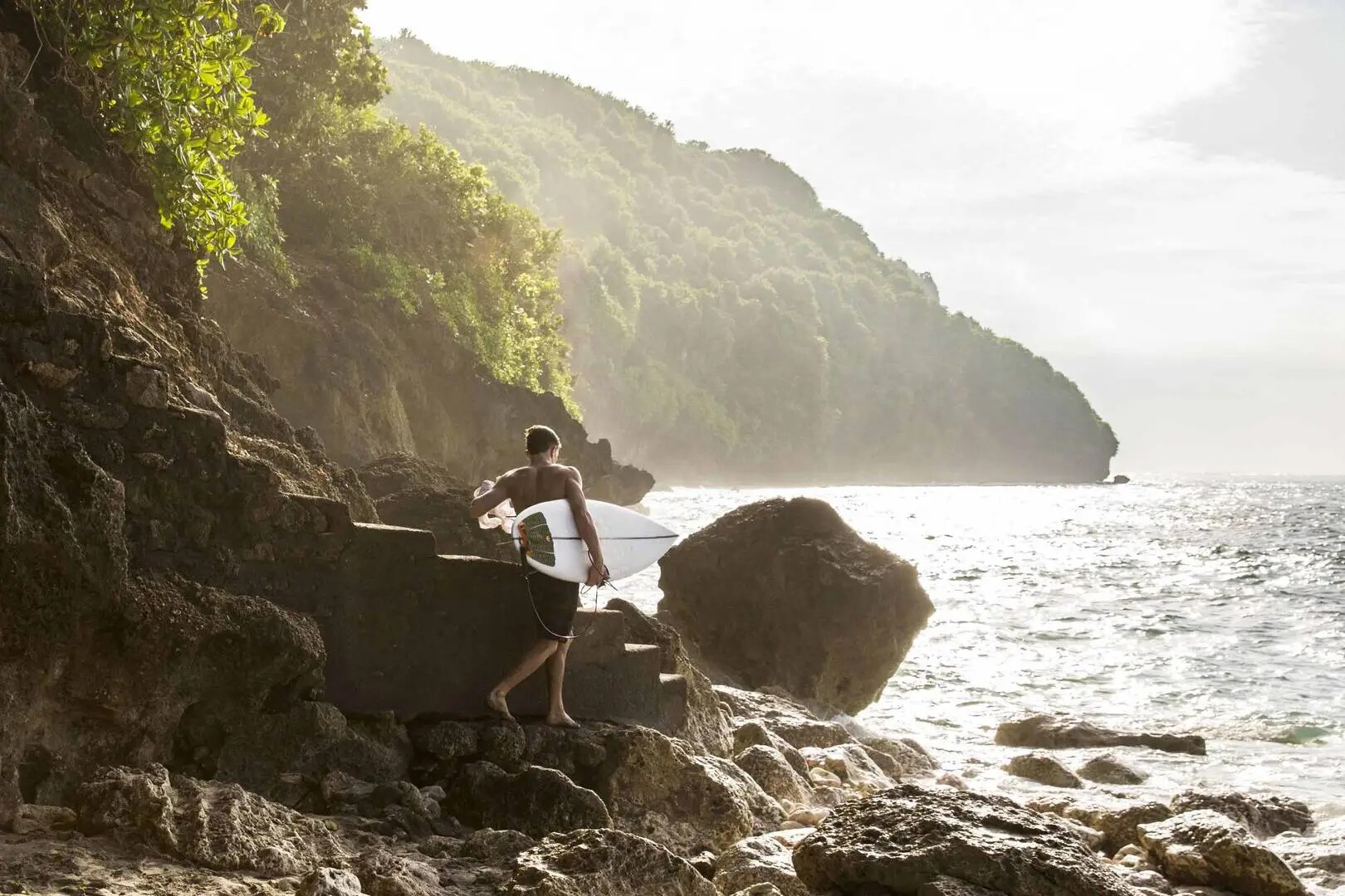 A man going surfing in Bali